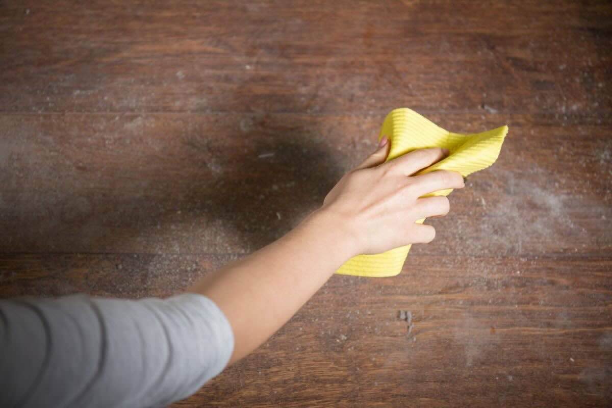 donna che spolvera legno