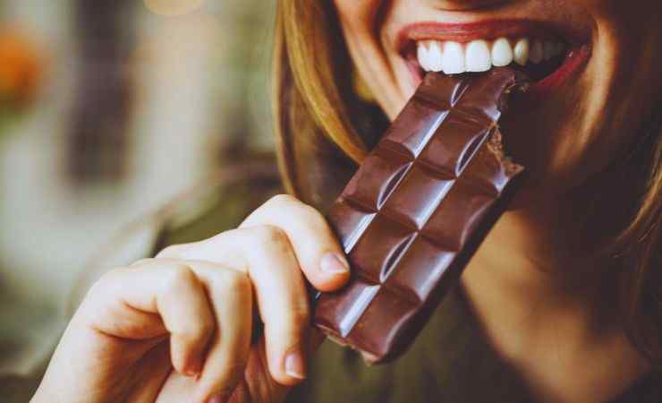 ragazza mangia barretta di cioccolato