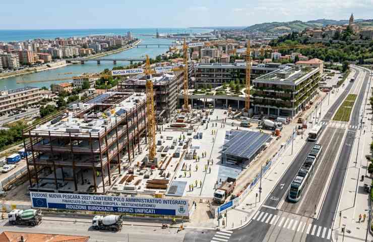 Cantiere del nuovo polo amministrativo Nuova Pescara 2027 con vista aerea sulla costa e le colline di Spoltore, progetto finanziato dal PNRR.