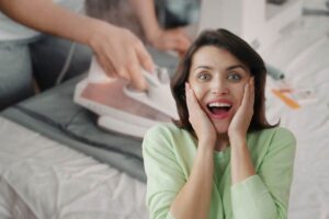 in primo piano una donna stupita e come sfondo una donna che stira