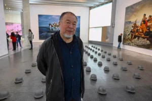 L'artista Ai Weiwei in posa a margine di una sua mostra.