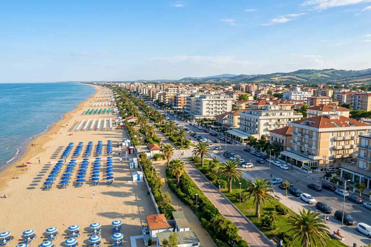Veduta aerea del lungomare di Alba Adriatica in Abruzzo con la spiaggia, il mare Adriatico e gli edifici della città sotto un cielo sereno.