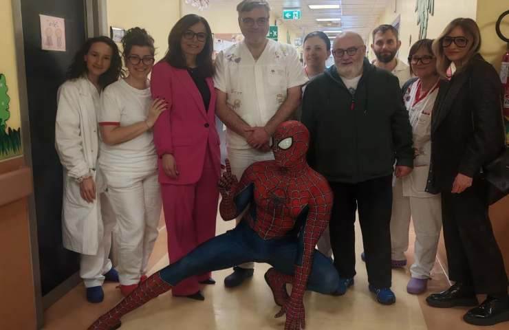Uomo con costume di Spider-Man in posa con infermiere e dottori dell'ospedale Mazzini di Teramo.