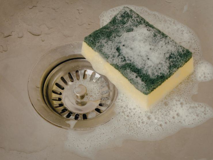 spugna dei piatti insaponata all'interno del lavello