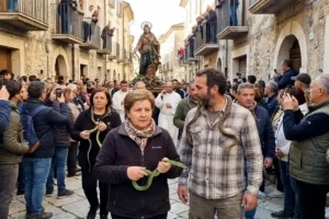 Processione del Rito dei Serpari a Cocullo con fedeli, serpenti e statua di San Domenico durante la festa del 1° maggio in Abruzzo.