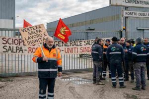 Lavoratori in presidio davanti allo stabilimento Verteza Salpa a Roseto degli Abruzzi con bandiere sindacali e cartelli di protesta.
