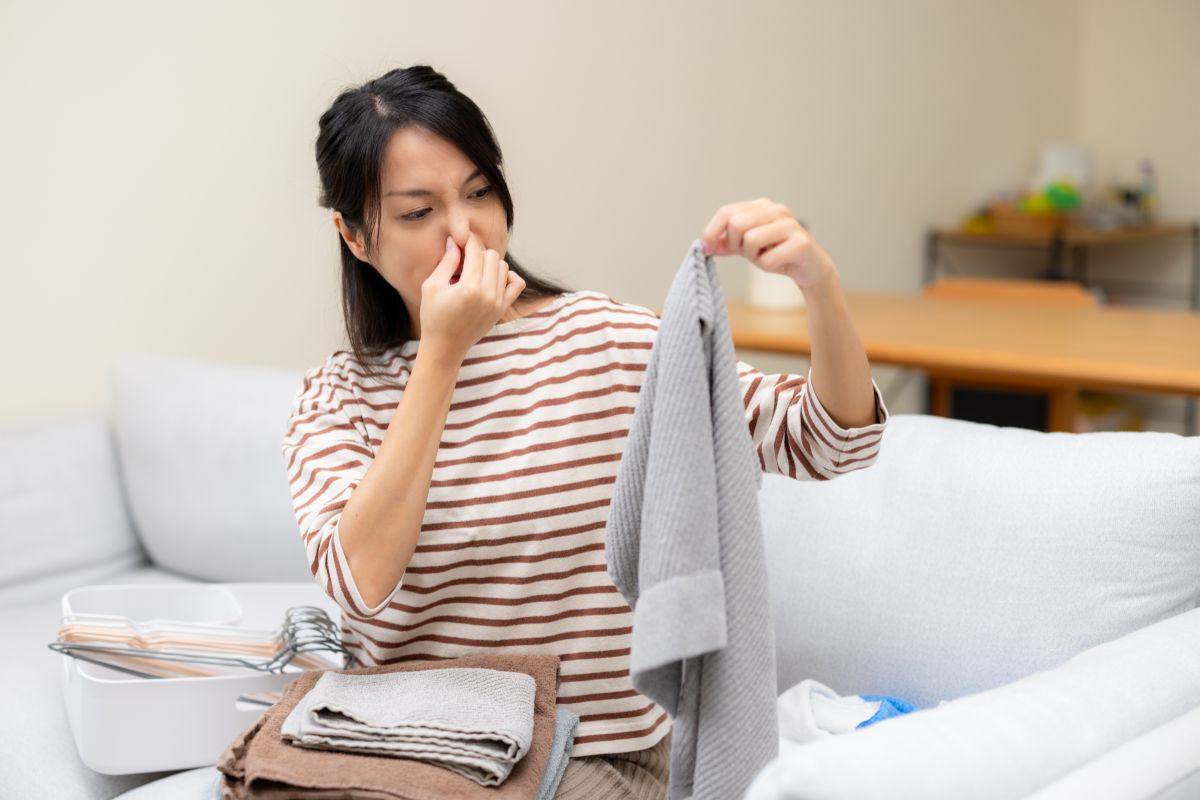 donna che si tappa il naso per il cattivo odore sui vestiti